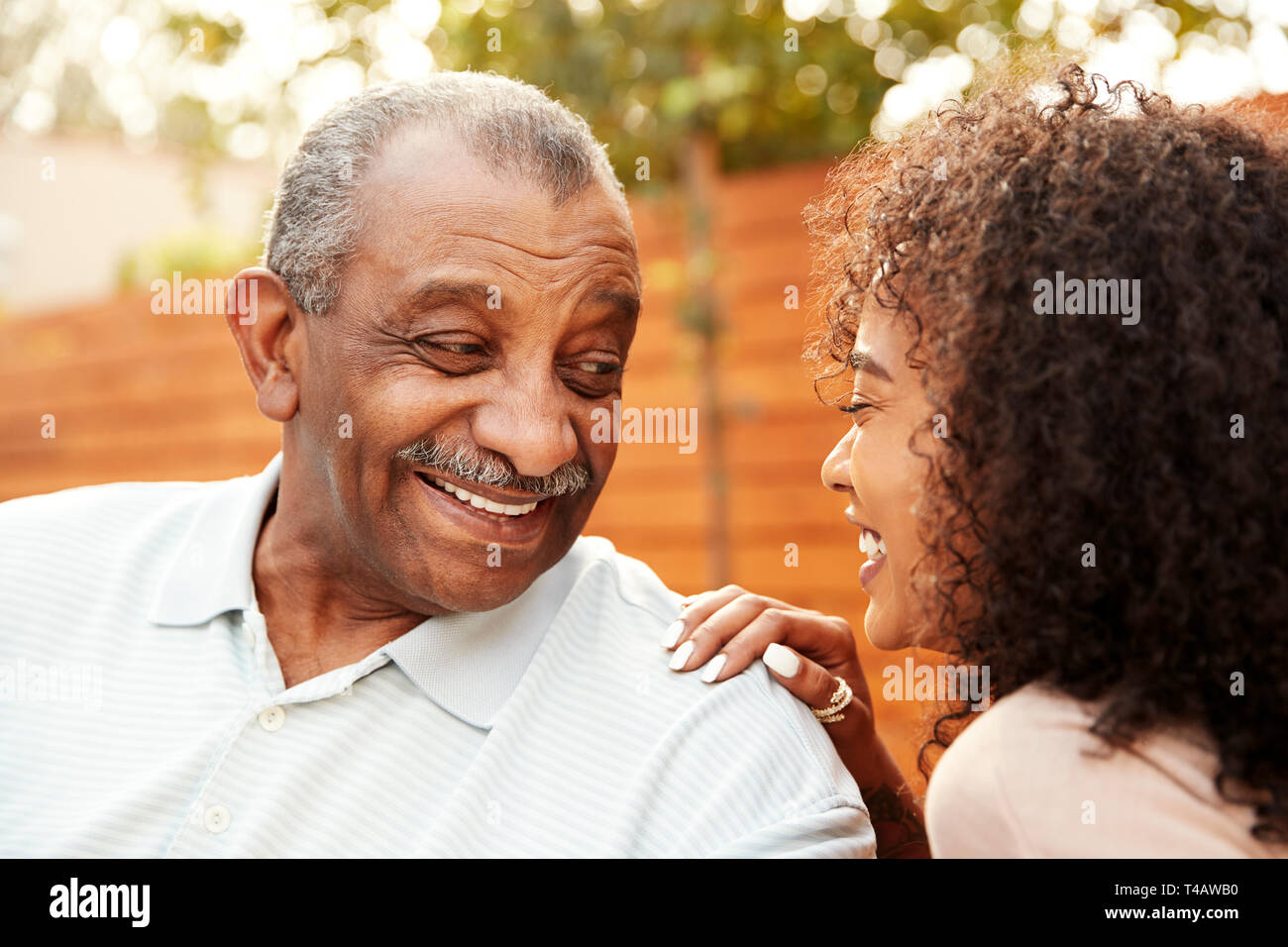 Senior black man and his adult granddaughter laughing outdoors, close up Stock Photo