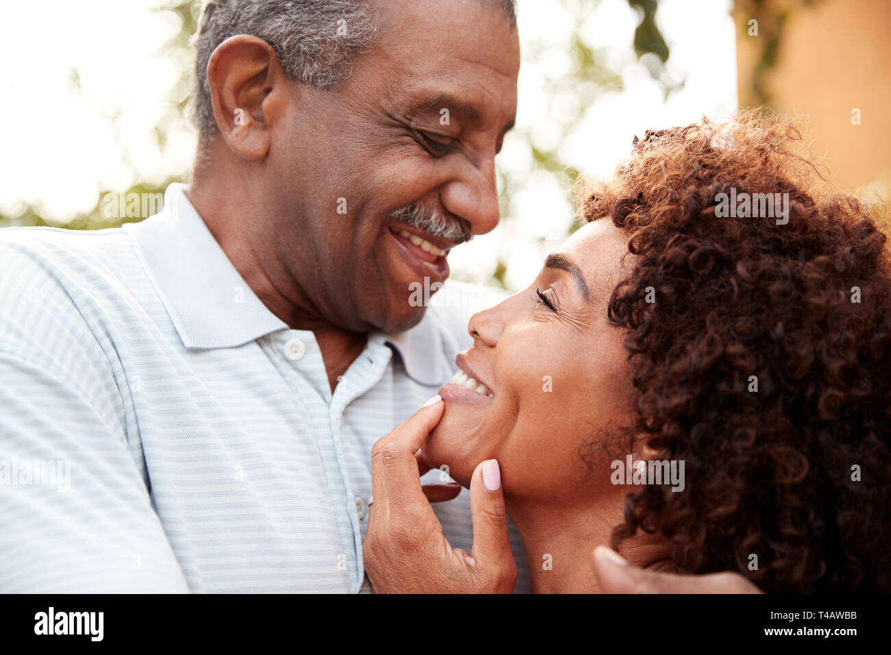 Senior man and his middle aged daughter smiling at each other embracing, close up Stock Photo