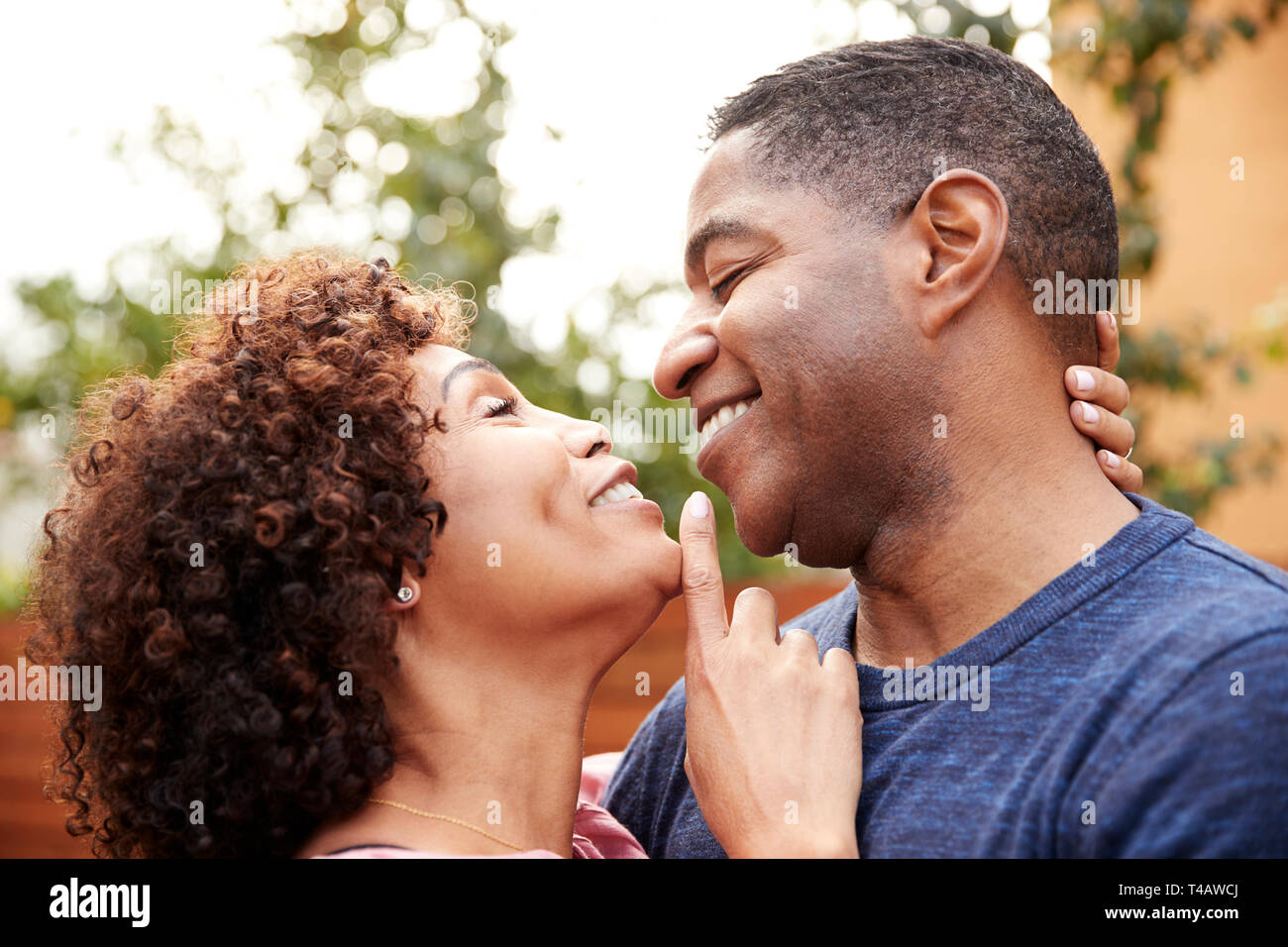 Happy middle aged black couple embracing outdoors, side view,close up Stock Photo