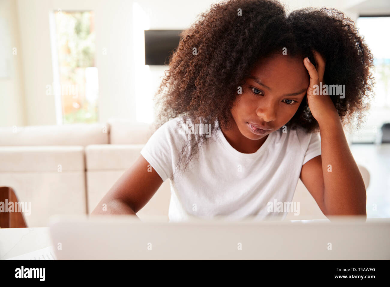 Young teenage black girl using laptop computer at home, close up Stock Photo
