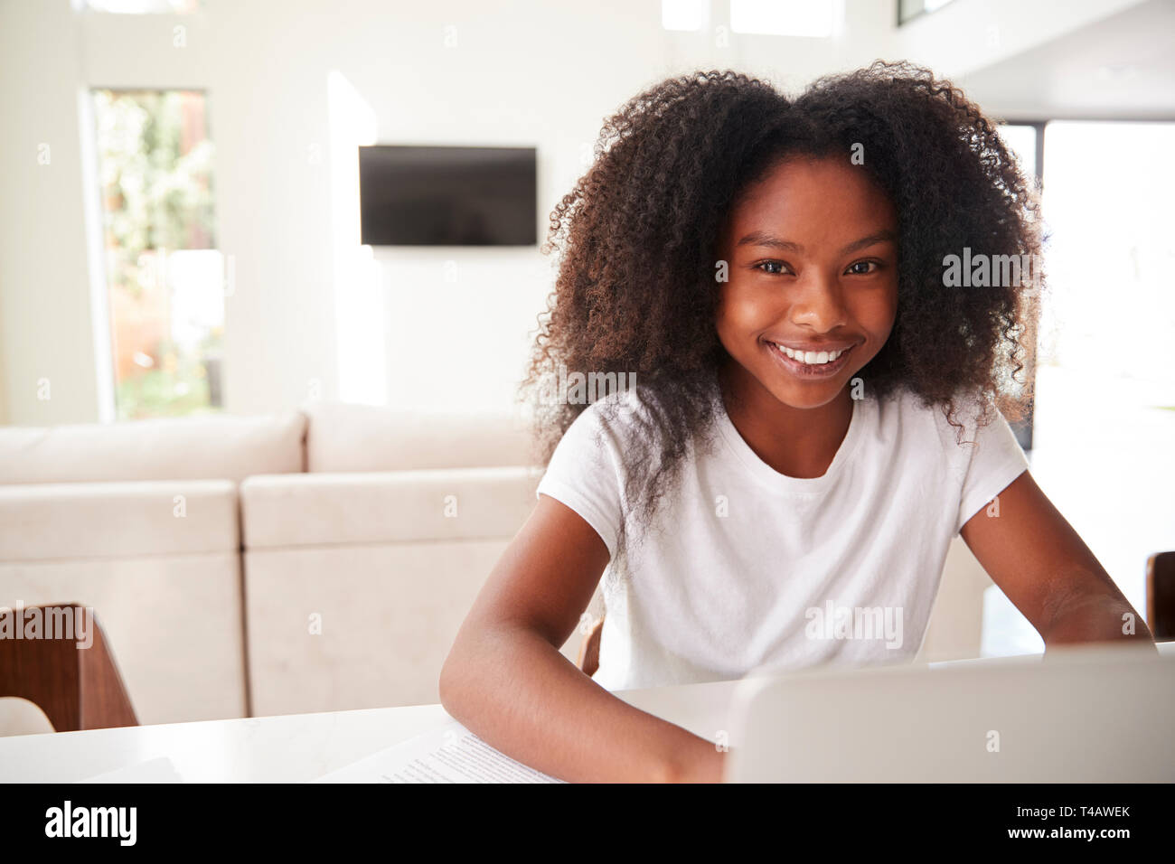 Happy young teenage black girl using laptop computer at home, close up Stock Photo