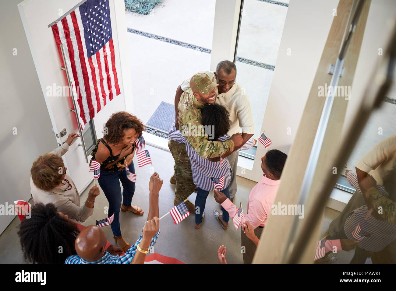 Young black male soldier welcomed home by three generation family, elevated view Stock Photo