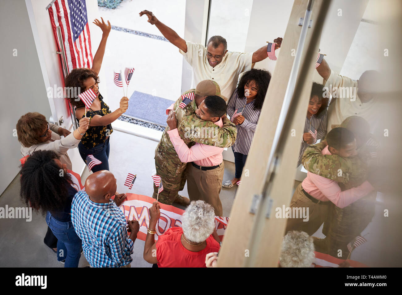 Young black male soldier welcomed home by three generation family, elevated view Stock Photo