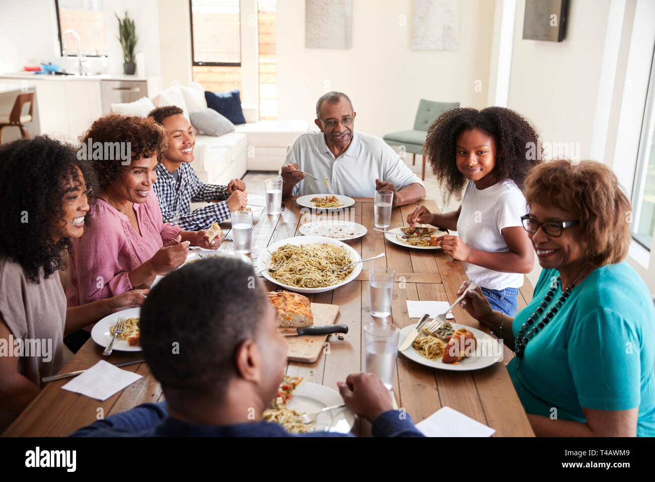 Three generation black family sitting at the table talking and eating