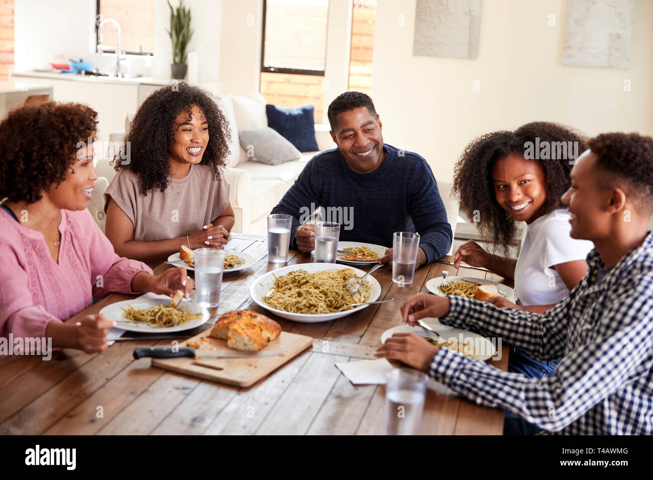 Middle aged black couple sitting at dinner table eating with their children, close up Stock Photo