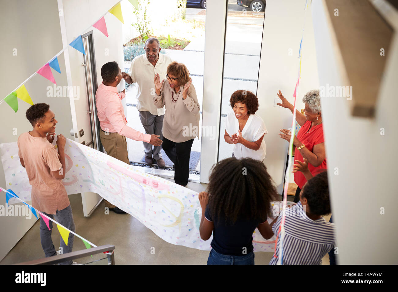 Three generation family throwing a surprise party guests at