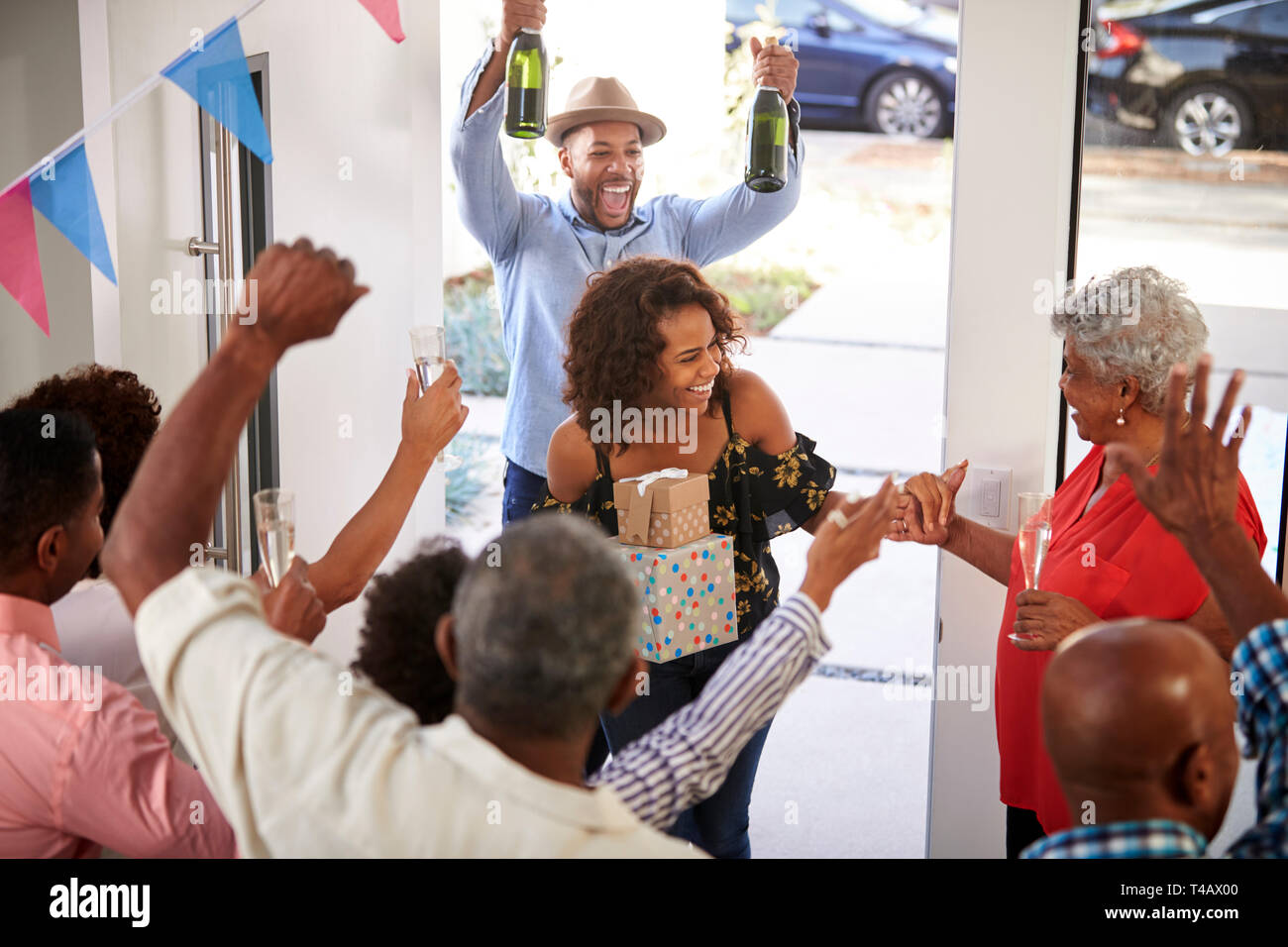 Three generation family throwing a surprise party guests at