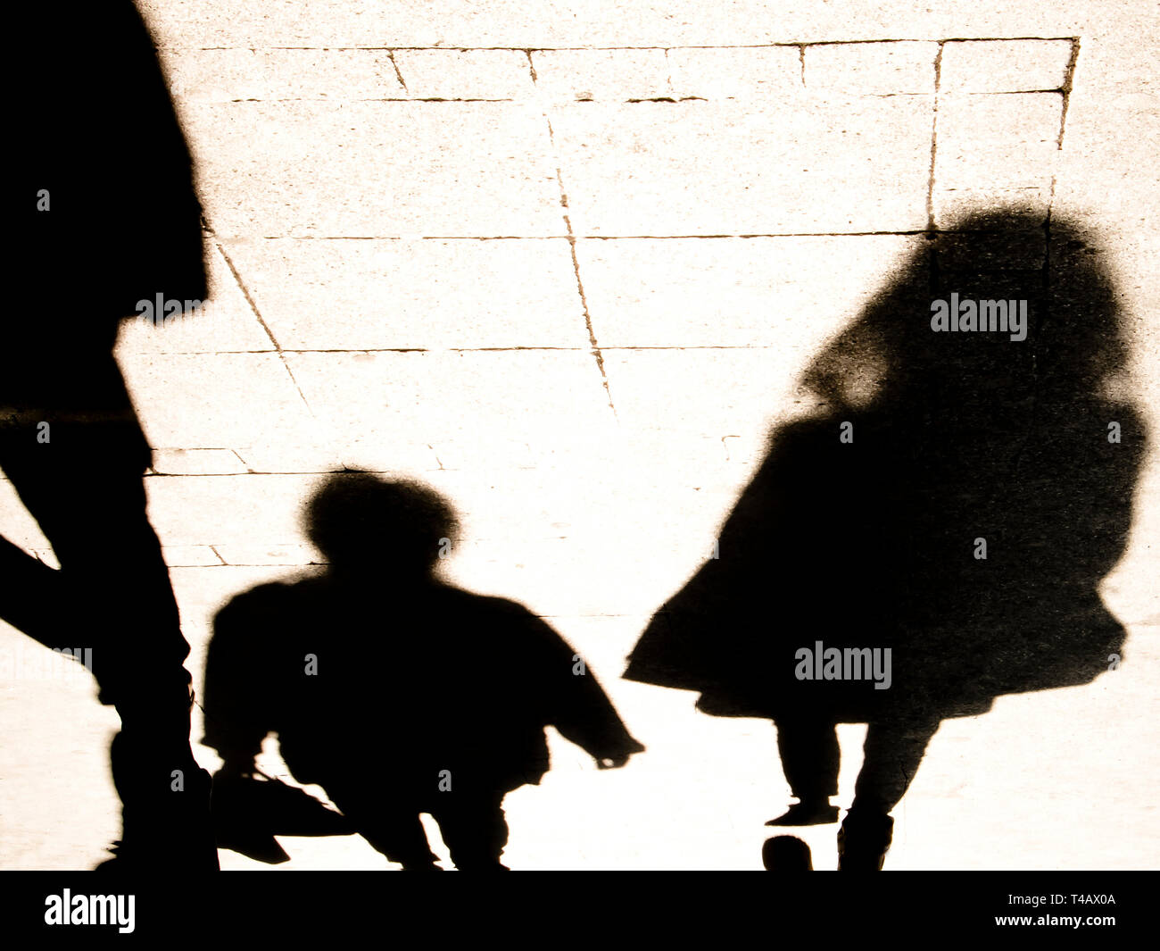 Blurrry shadow silhouete of  people walking in high contrast sepia black and white Stock Photo