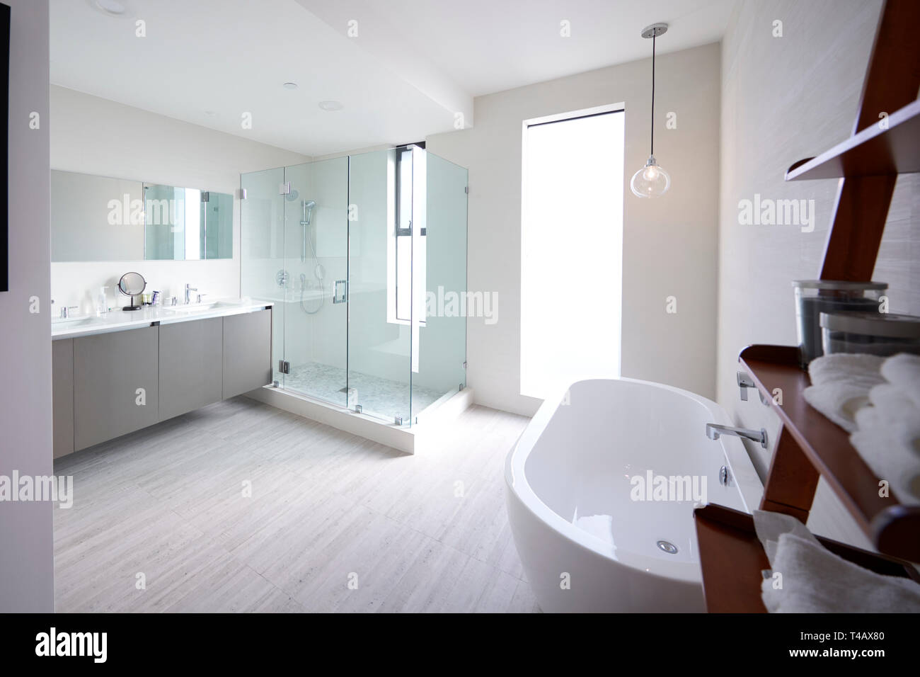 Modern domestic bathroom with shower cabin and freestanding bath, sunlight, no people Stock Photo