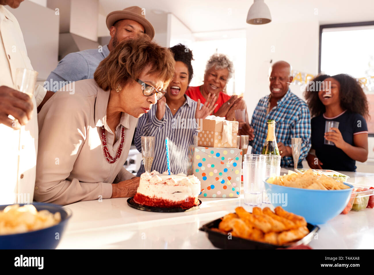 Middle aged black woman cutting cake during a three generation family birthday celebration,close up Stock Photo