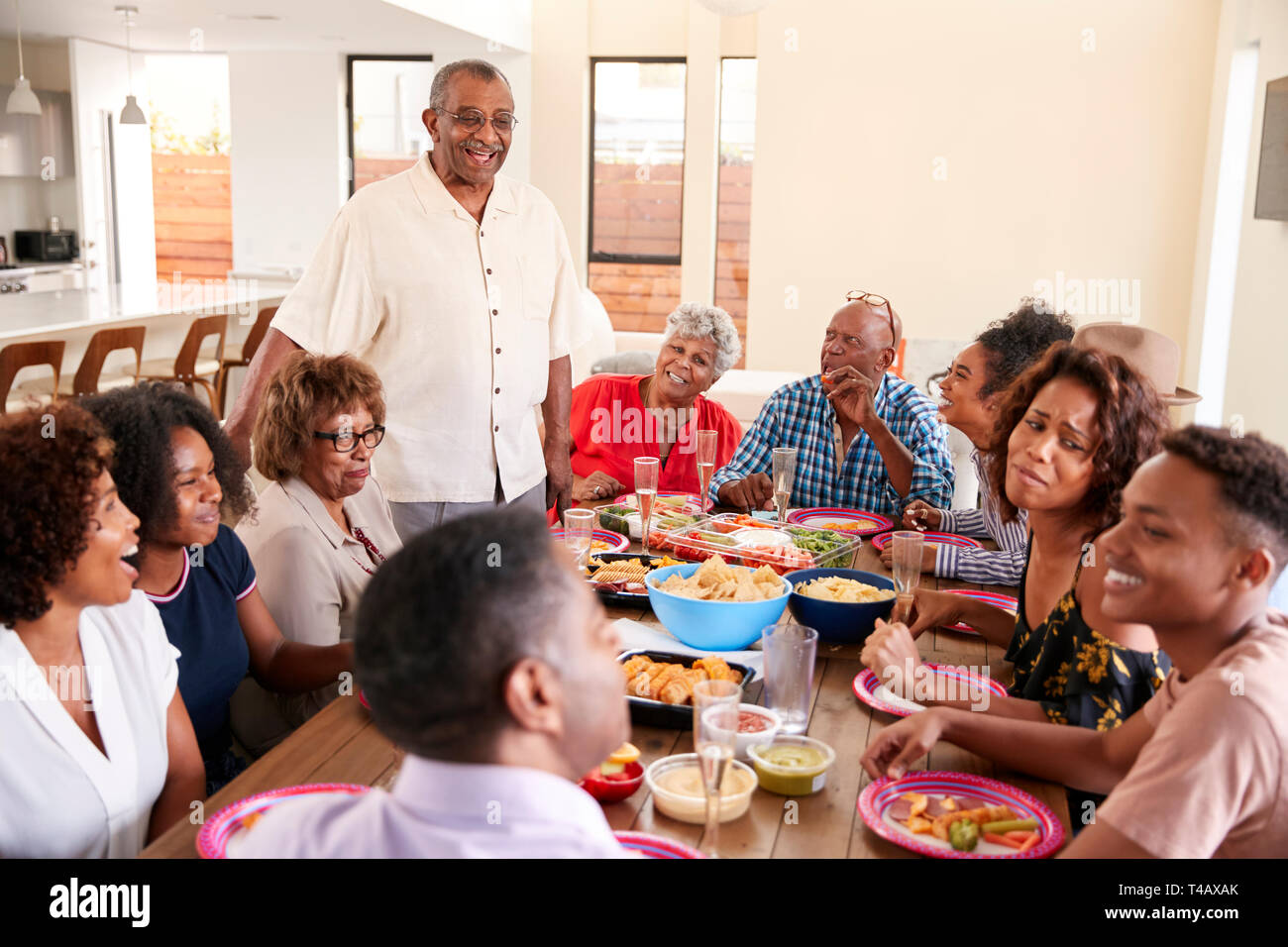 Three generation black family sitting at dinner table celebrating together,close up Stock Photo