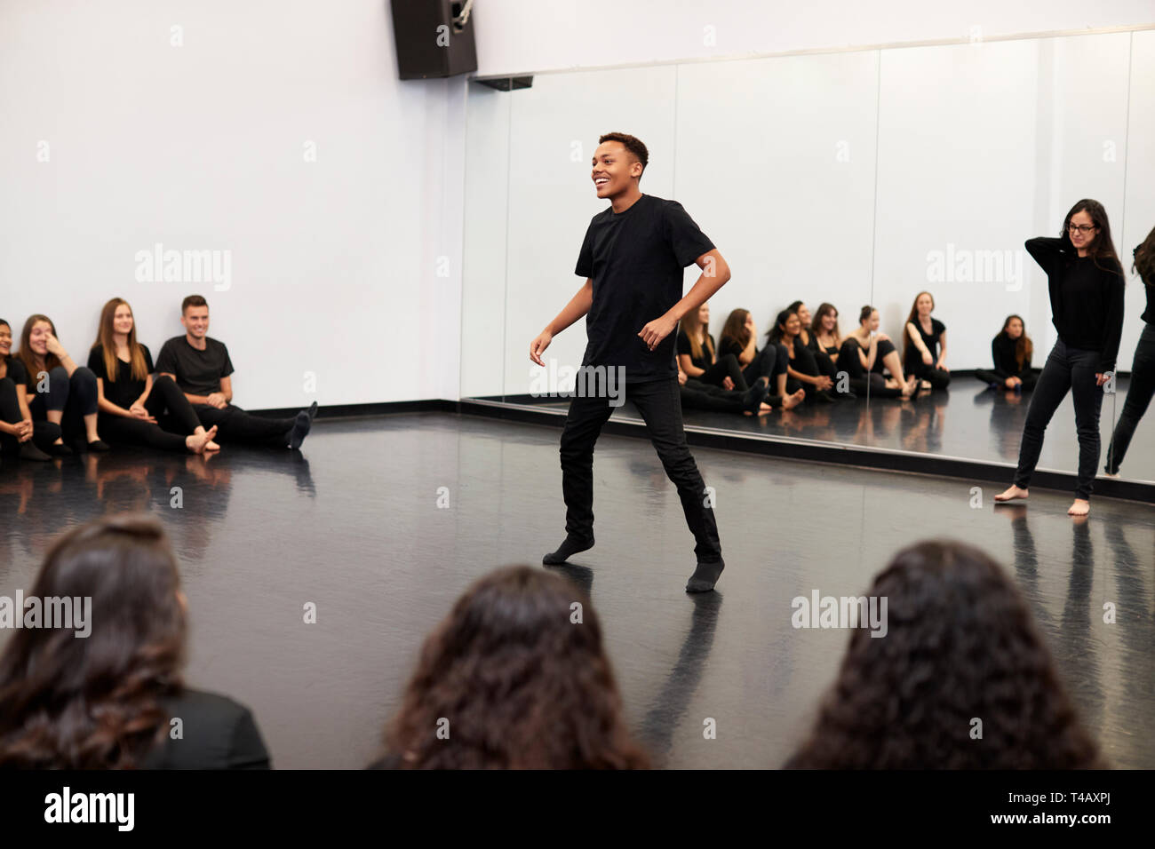 Male Student At Performing Arts School Performs Street Dance For Class And Teacher In Dance Studio Stock Photo