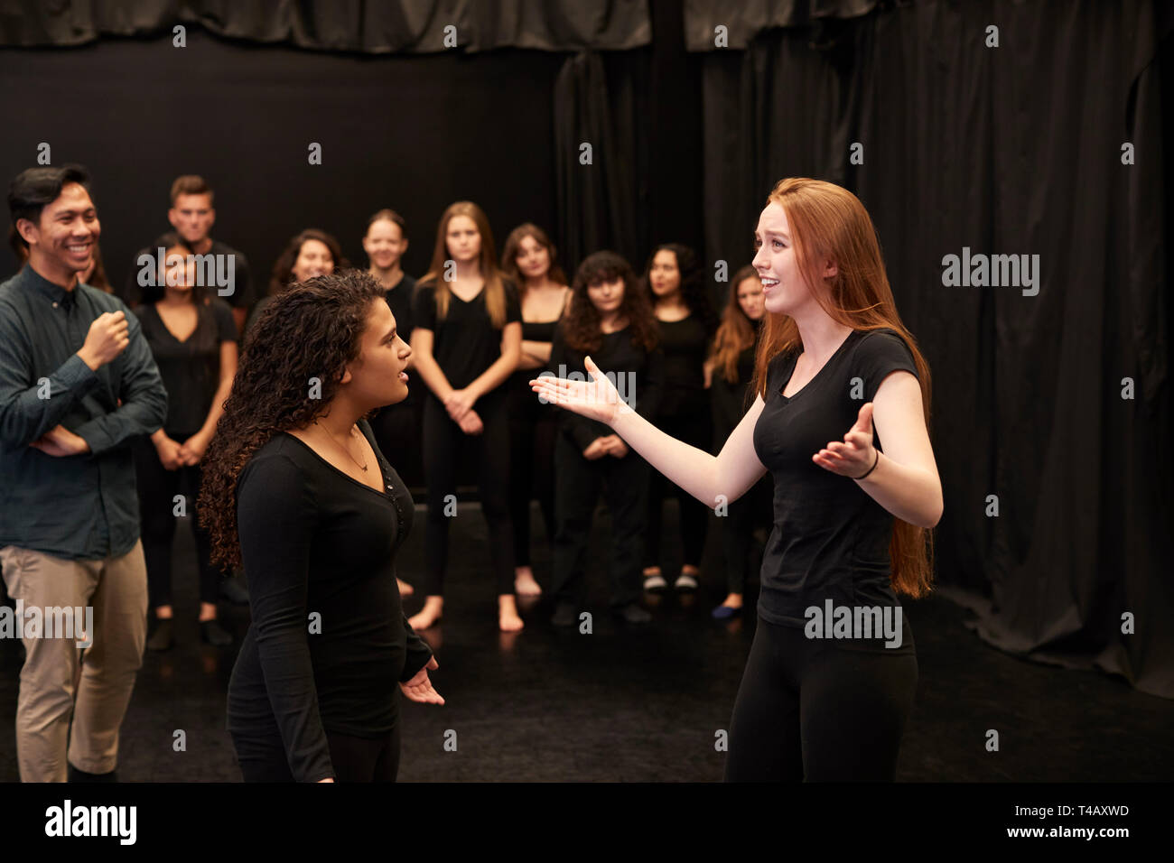 Teacher With Male And Female Drama Students At Performing Arts School In Studio Improvisation Class Stock Photo