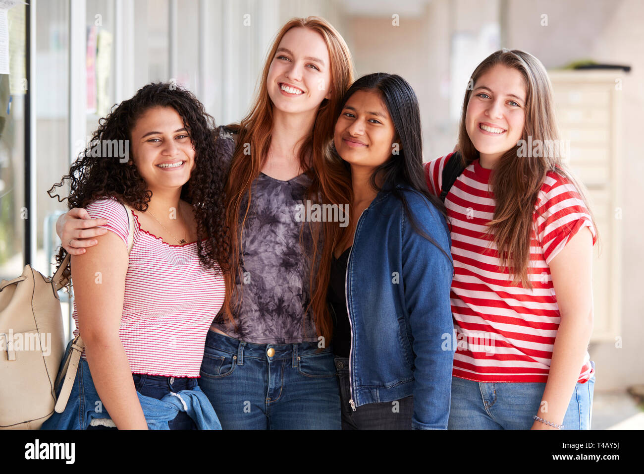 Portrait Of Smiling Female College Student Friends In Corridor Of ...