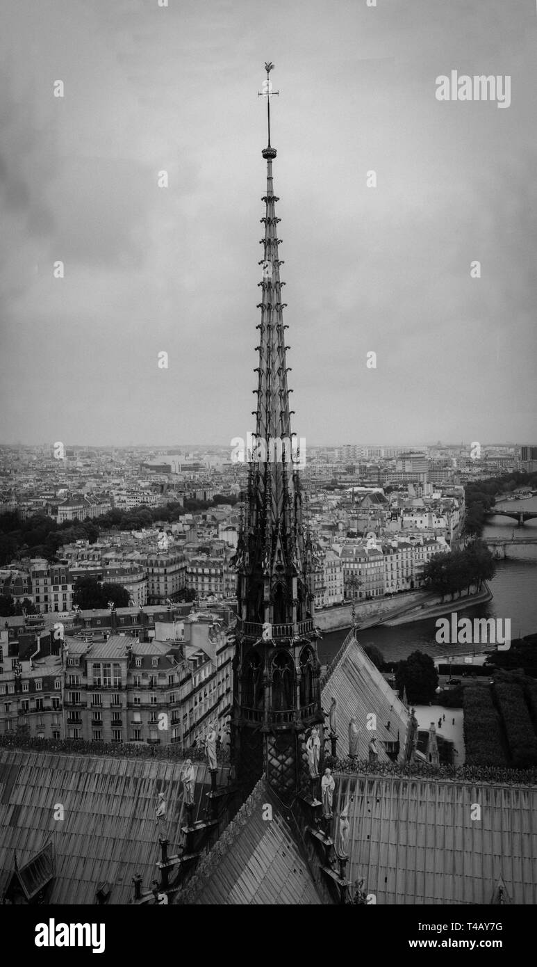 The spire of Notre Dame de Paris, panoramic view of Paris and river Seine from the roof of Notre Dame cathedral, France. Cloudy weather. Stock Photo