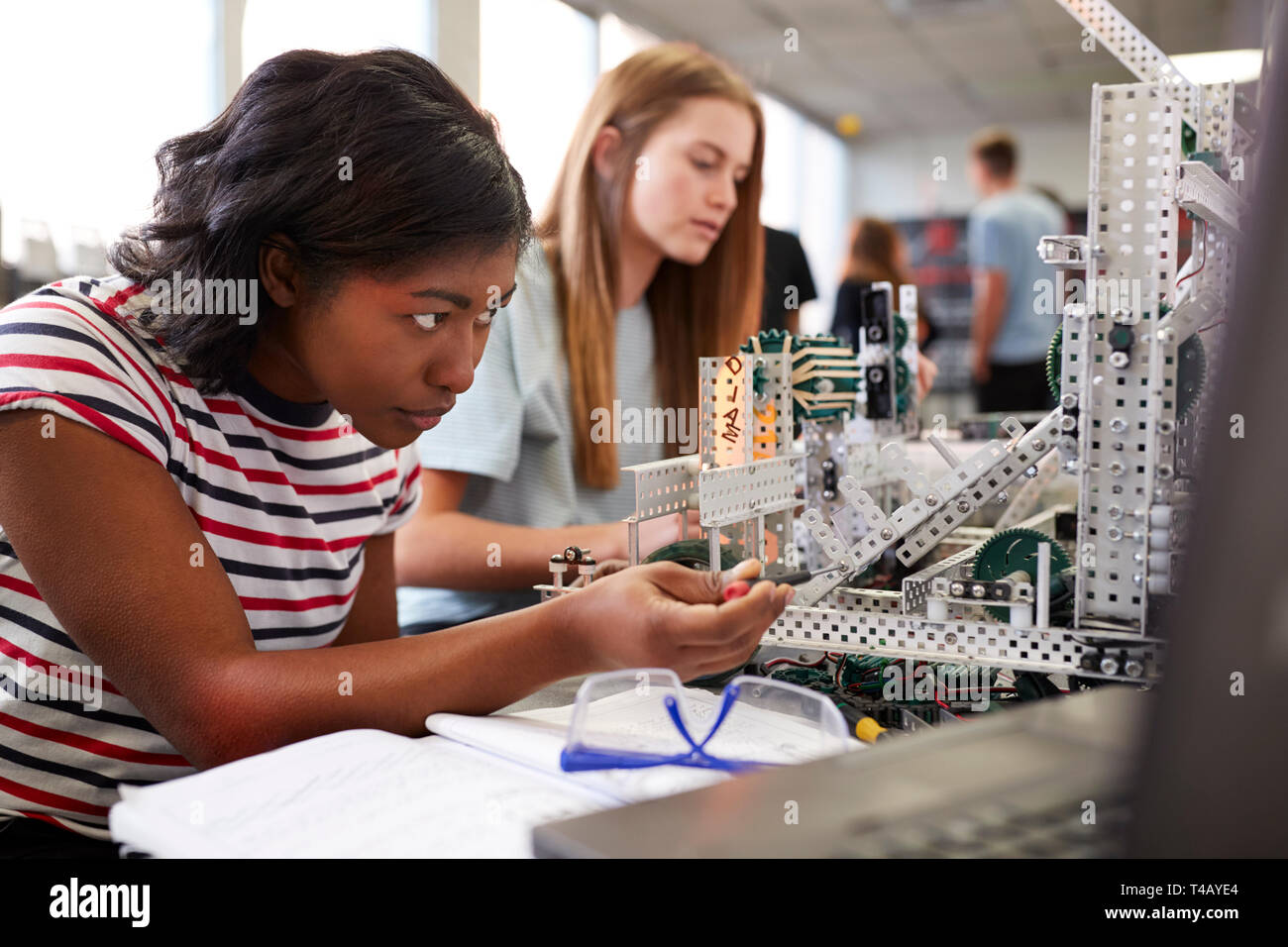Student Using A Machine Two Female College Students Building Machine In Science Robotics Or ...