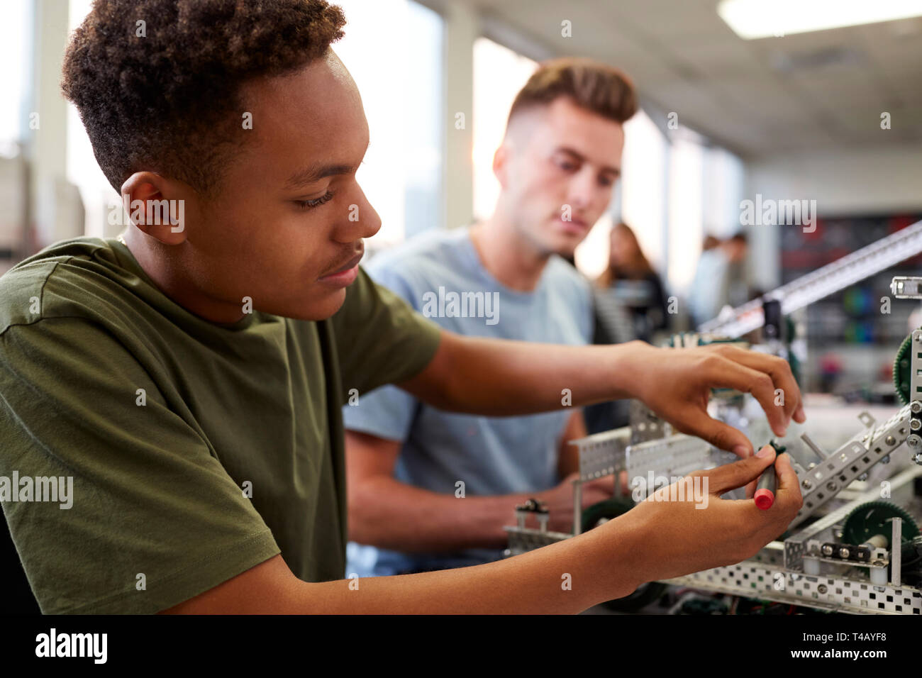 Two Male University Students Building Machine In Science Robotics Or Engineering Class Stock Photo