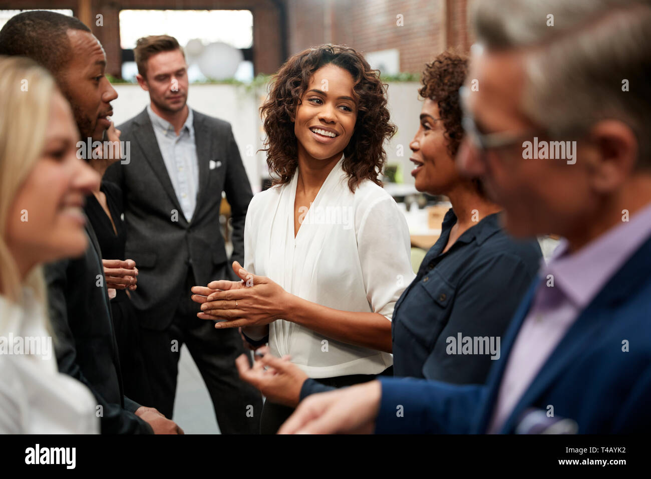 Business Team Standing Having Informal Meeting In Modern Office Stock Photo