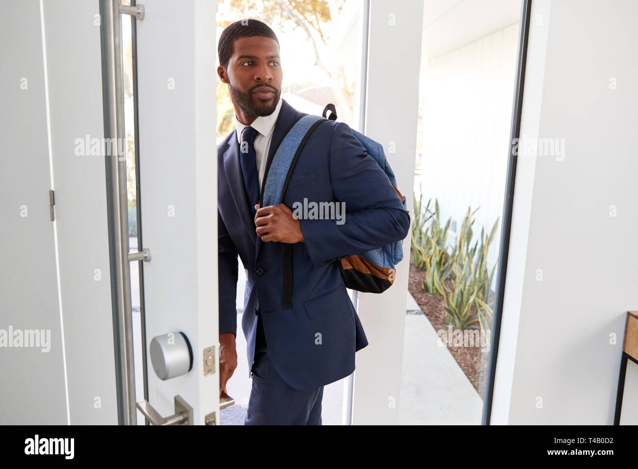 Businessman Wearing Suit Opening Door Leaving Home For Work Stock Photo