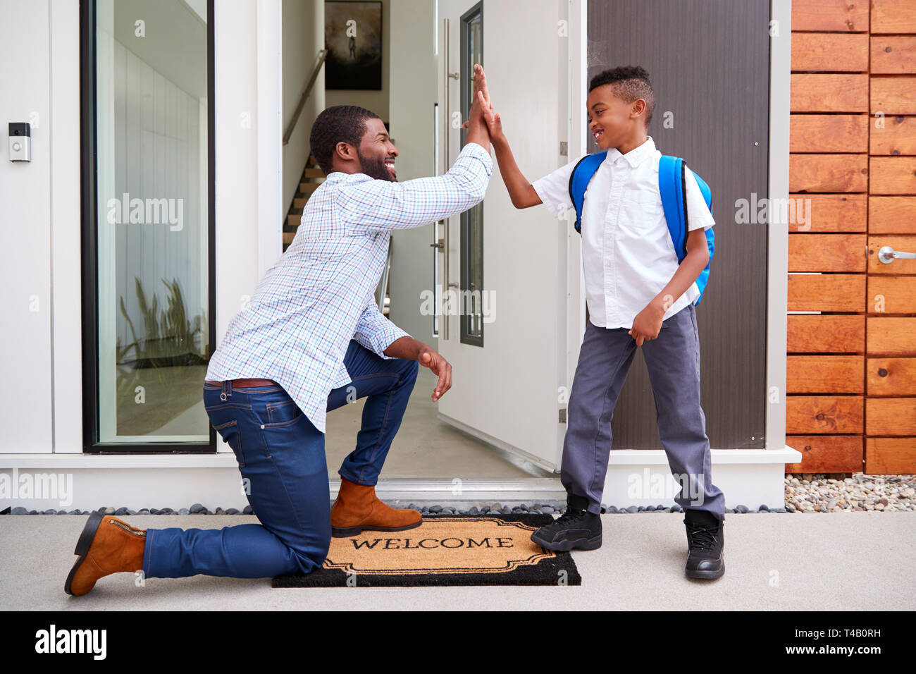 Father Giving Son High Five As He Leaves For School Stock Photo