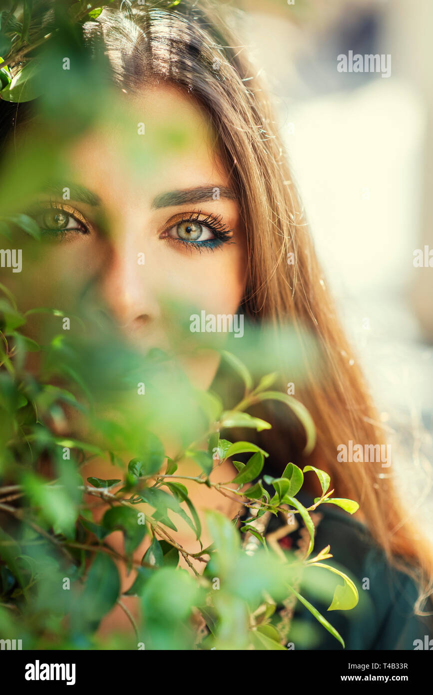 Beautiful woman hiding her face with leaves Stock Photo - Alamy