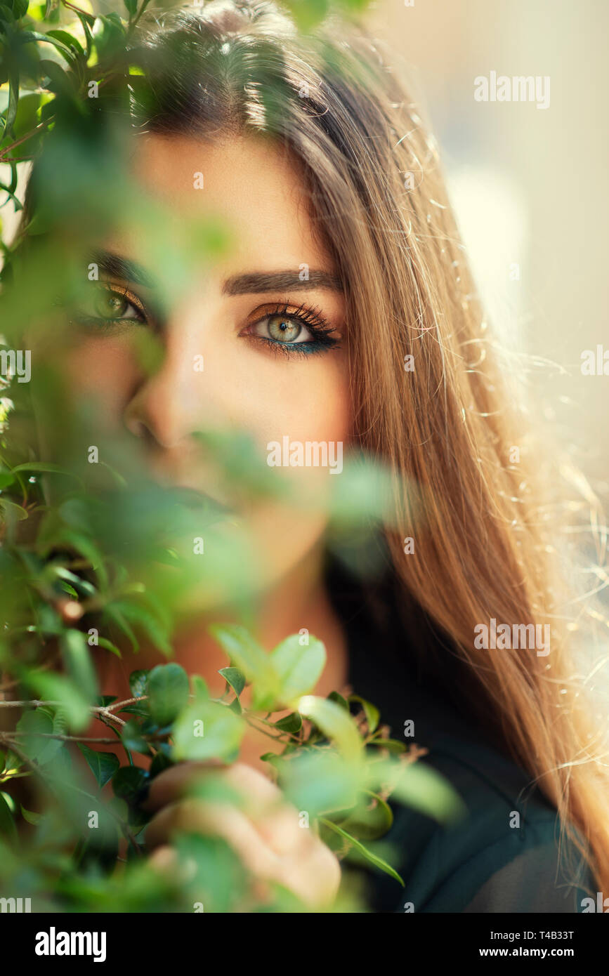 Beautiful woman hiding her face with leaves Stock Photo - Alamy