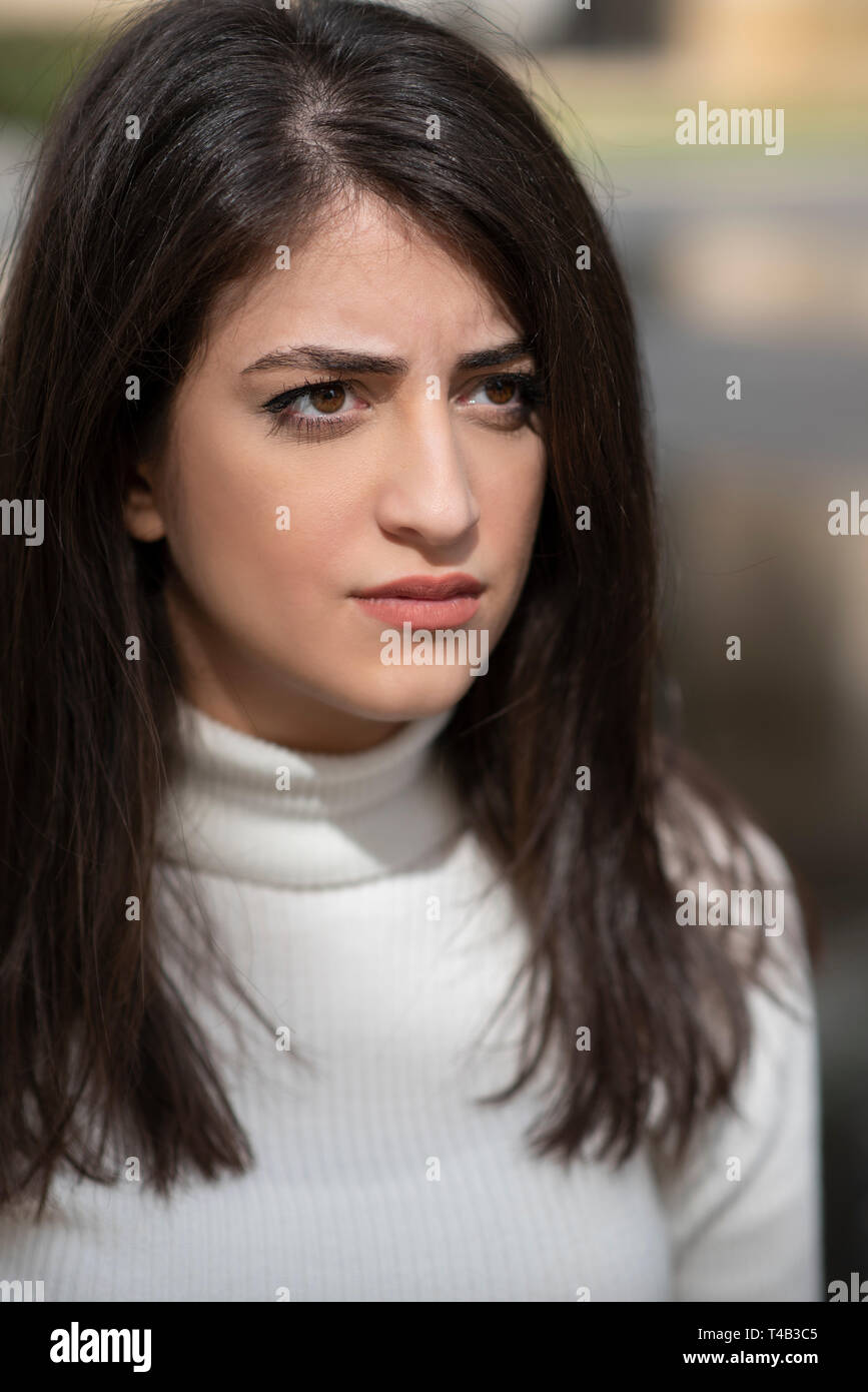 Serious young woman looking away outdoors Stock Photo