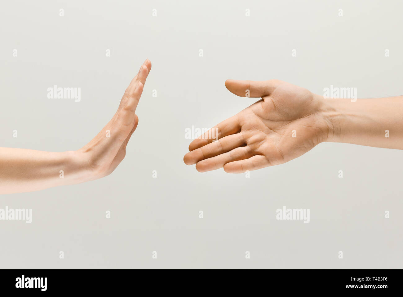 Leave the aggression with you. Two male hands showing sign of greetings and stopping isolated on grey studio background. Concept of human relations, disagreement, renouncement and resistance. Stock Photo