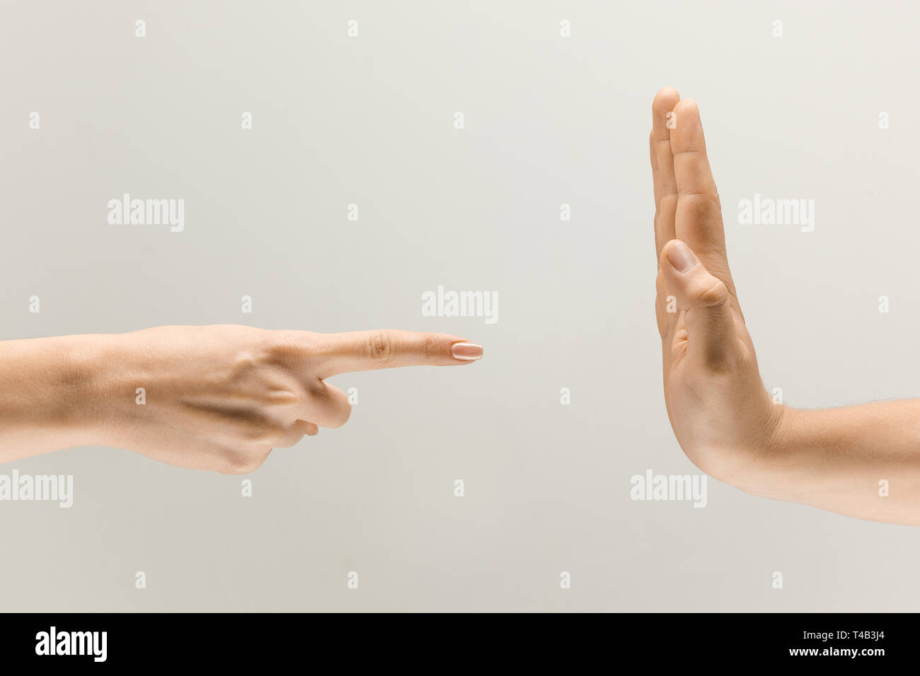 Woman rights. Two human hands showing sign of stopping isolated on grey studio background. Concept of human relations, disagreement, renouncement and resistance. Stock Photo