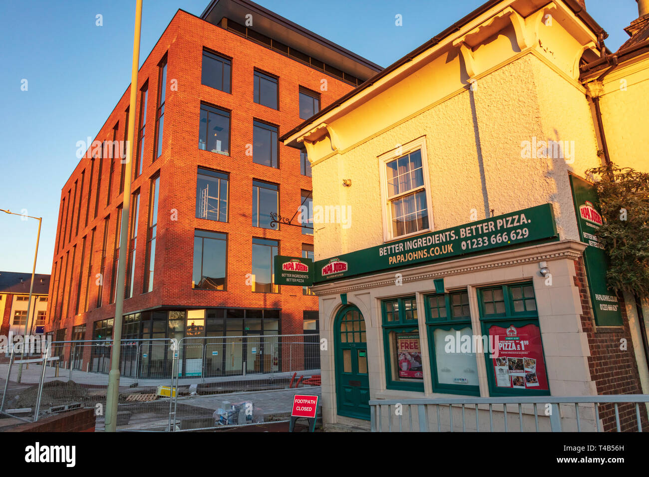 Papa Johns in an old pub amidst the new developments in Ashford Town Centre in Kent, in warm evening light, UK Stock Photo