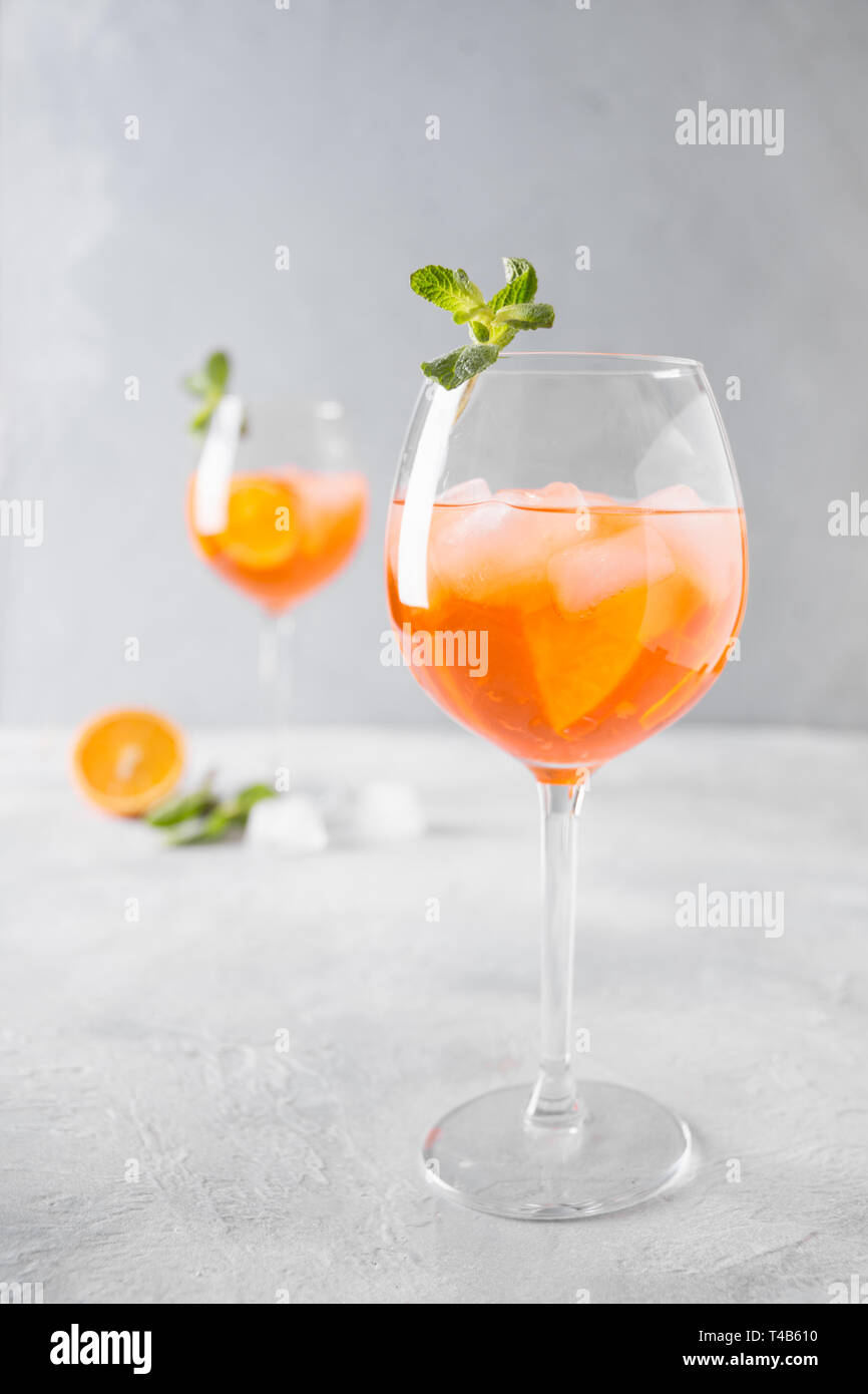 Classic Italian aperol spritz cocktail in wine glass with metal straw on light. Close up. Stock Photo