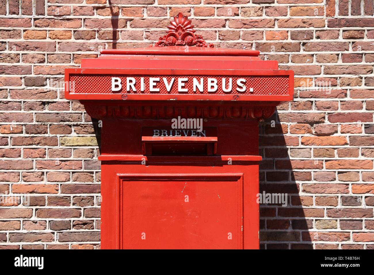 Red post box in Amsterdam, Netherlands. Brievenbus means letter box in  Dutch Stock Photo - Alamy