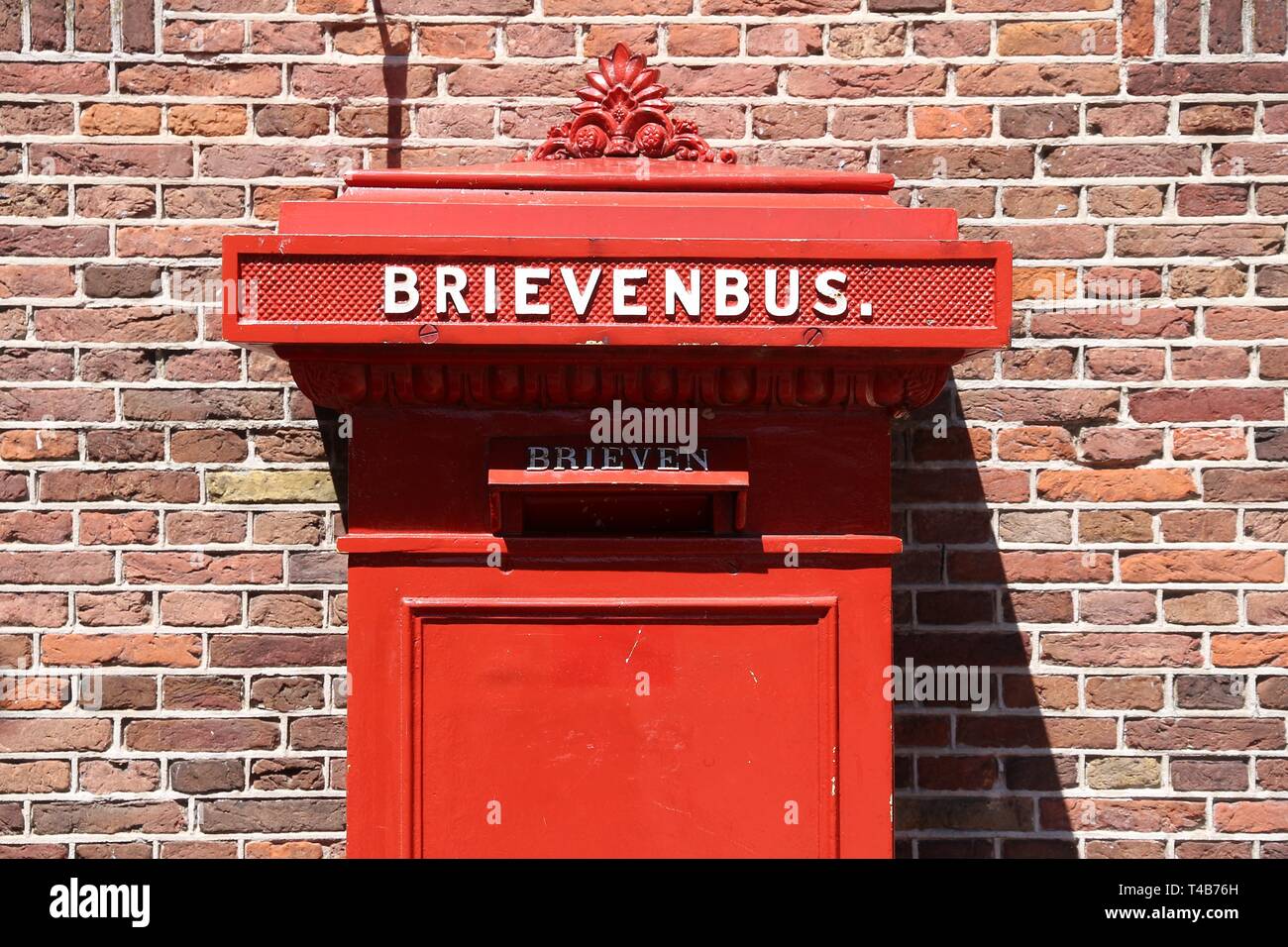 Red post box in Amsterdam, Netherlands. Brievenbus means letter box in ...