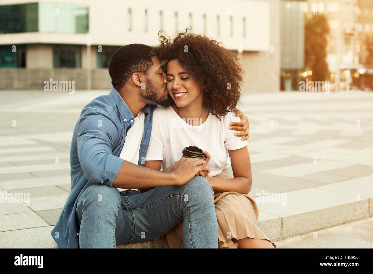 Couple in love drinking coffee, man kissing girlfriend Stock Photo