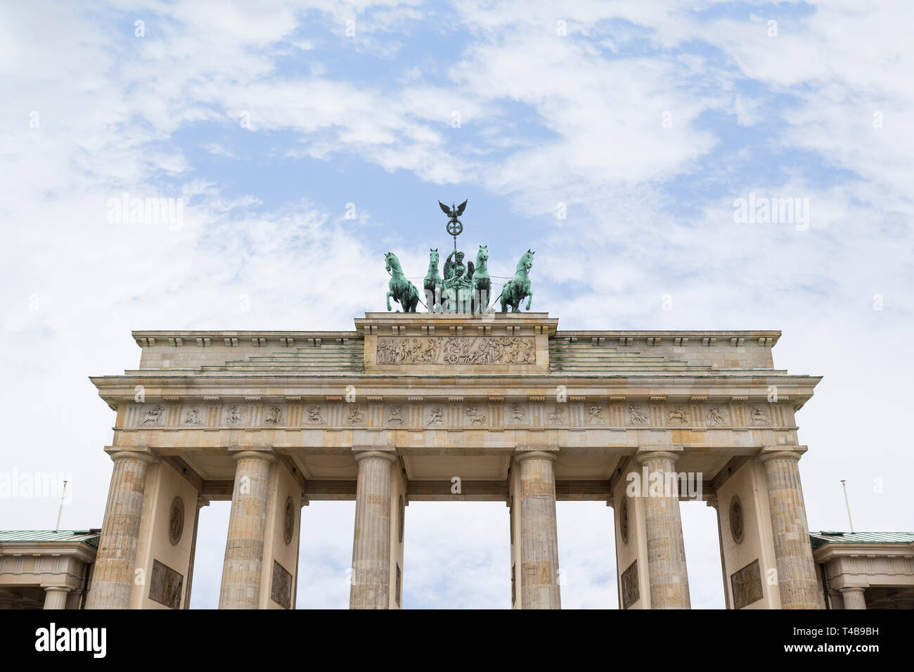 Famous neoclassical Brandenburg Gate (Brandenburger Tor) in Berlin, Germany, on a cloudy day. Copy space. Stock Photo