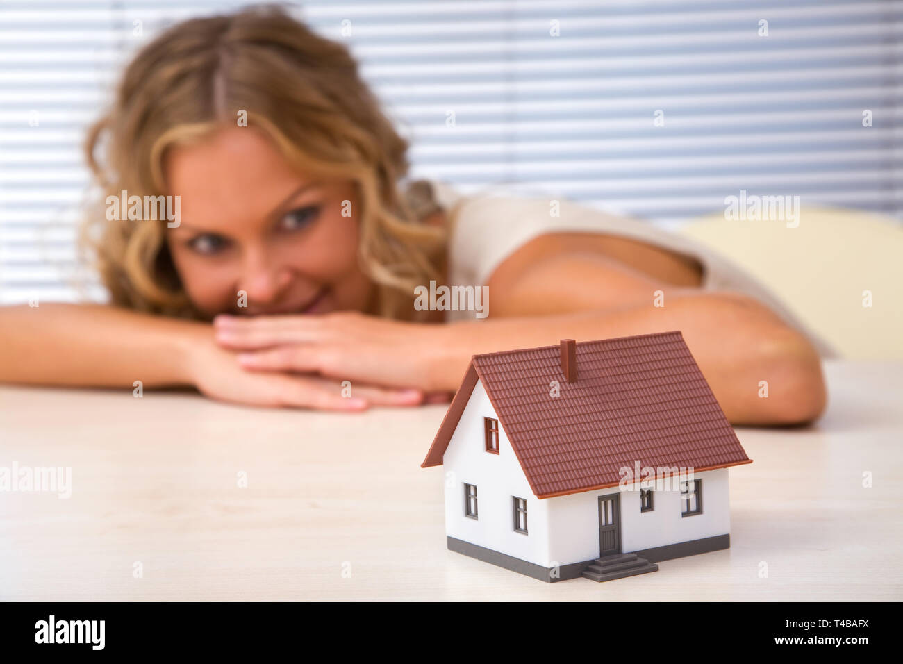 real estate concept with happy businesswoman and mini house Stock Photo ...