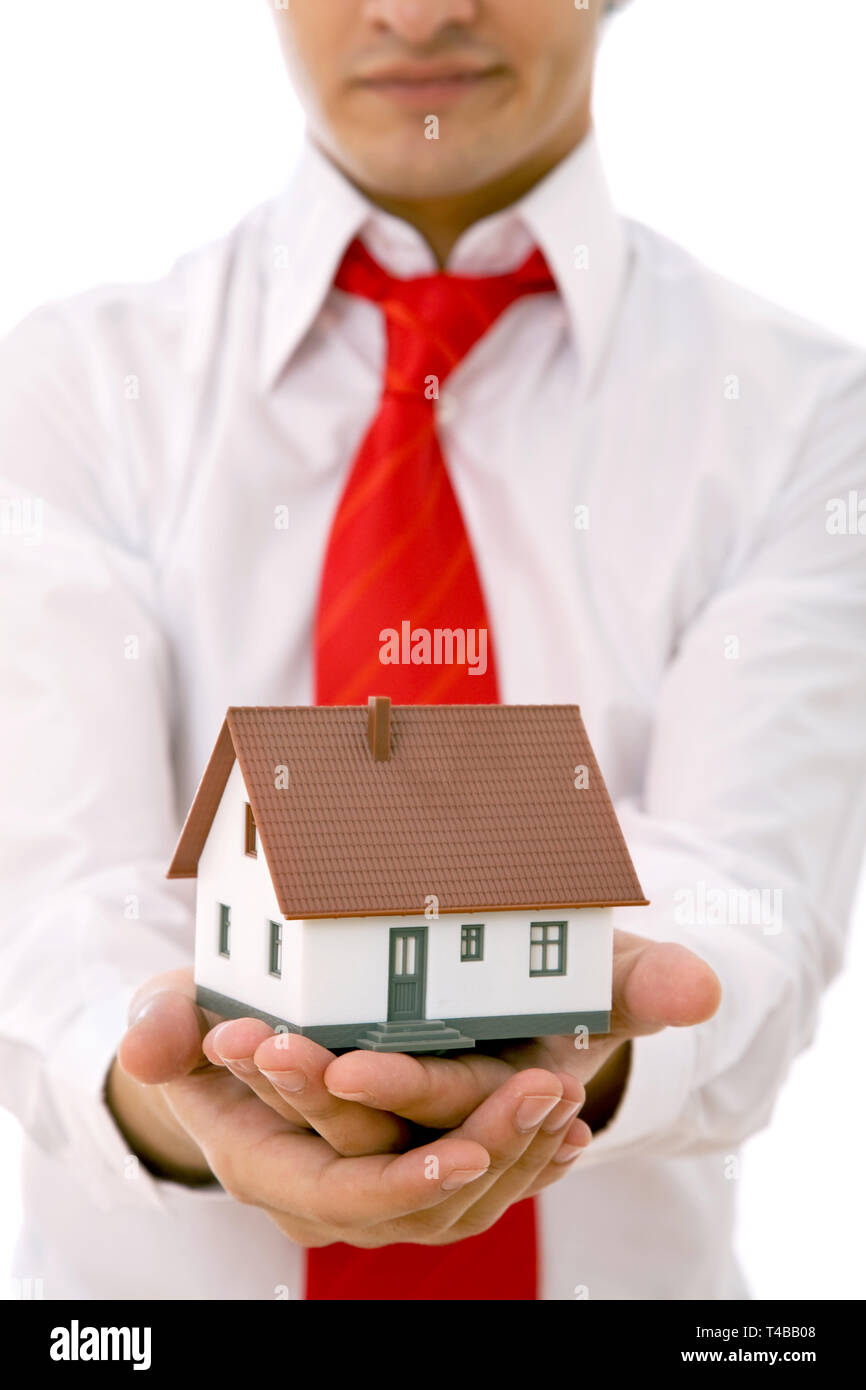 Real estate concept with a businessman holding a mini house Stock Photo ...