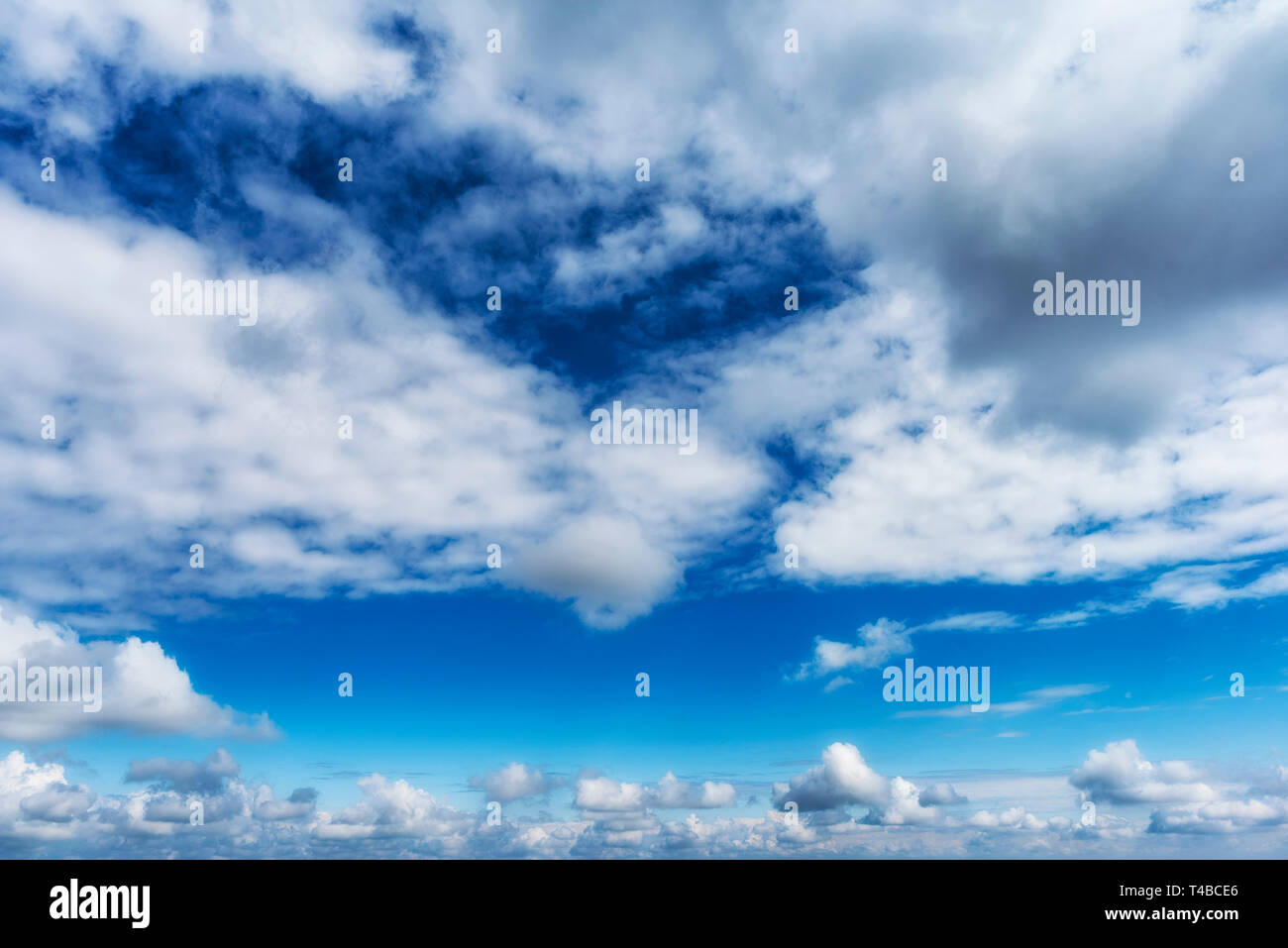 Blue sky with white puffy clouds Stock Photo - Alamy
