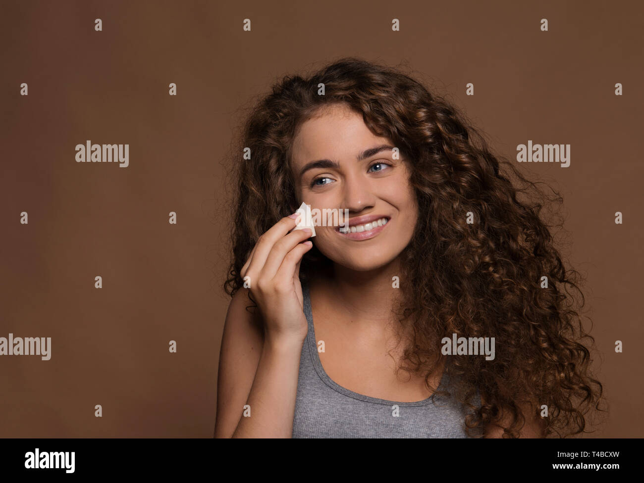 Portrait of a young woman in a studio, brown background. Beauty and skin care. Stock Photo