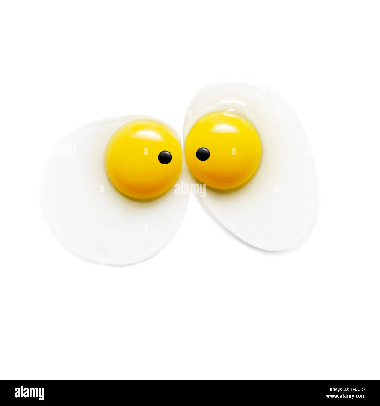 Two egg yolks with eyes on white background Stock Photo