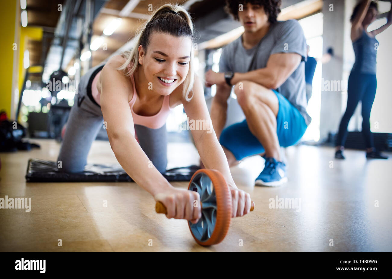 Healthy young athletes doing exercises at fitness studio Stock Photo