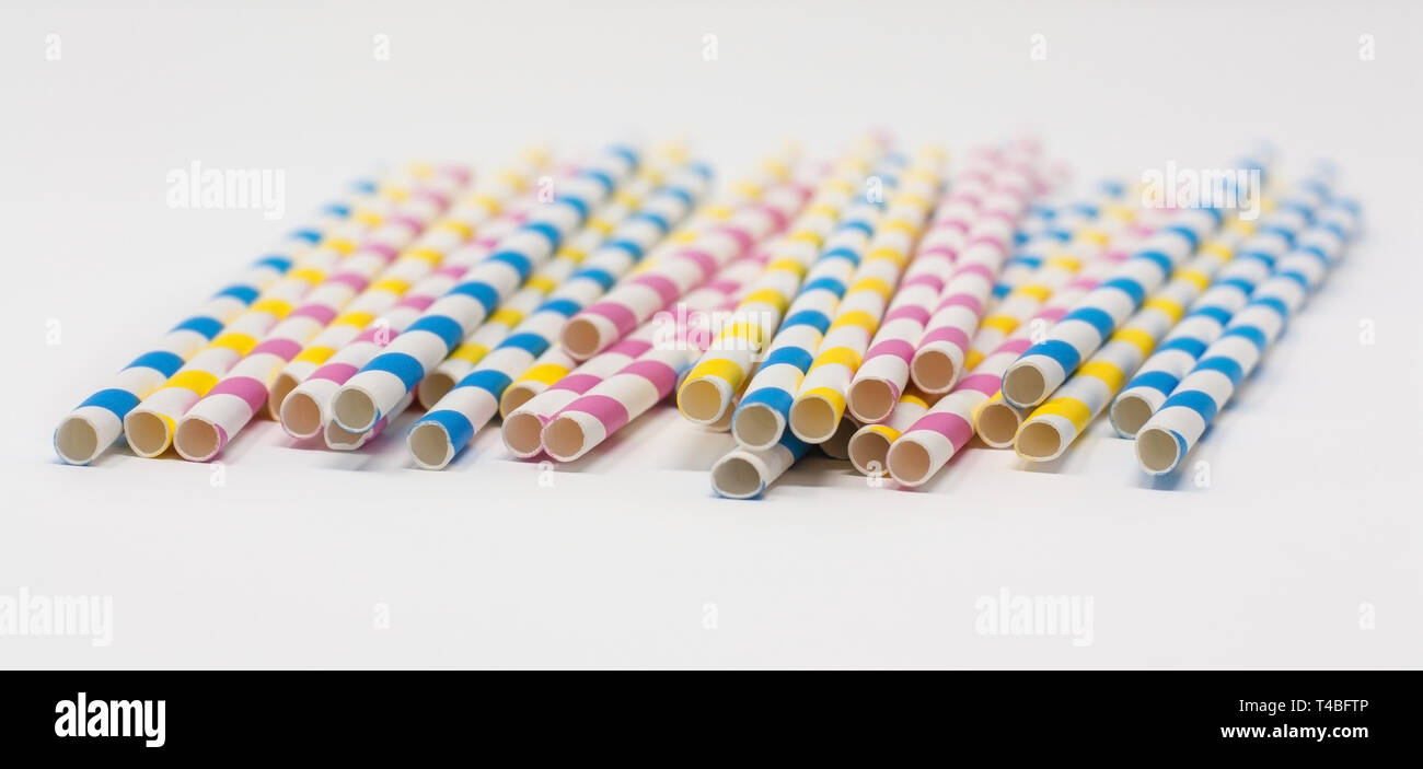 Striped biodegradable paper straws, isolated against a white background with a shallow depth of field Stock Photo