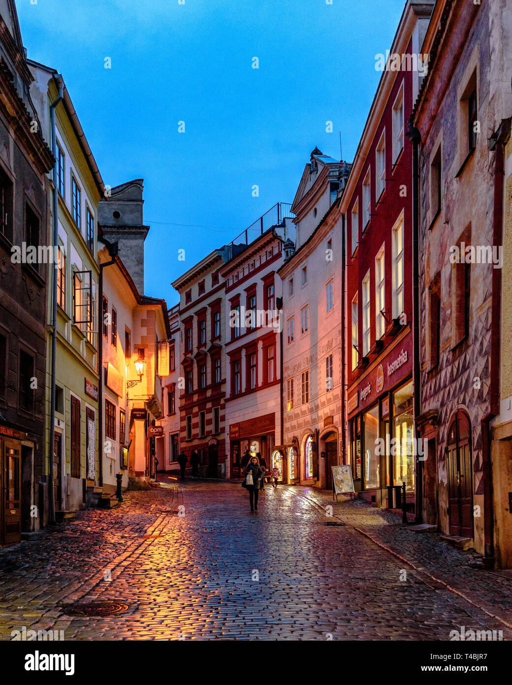 A street with wet cobblestones in the old town of Cesky Krumlov at dusk Stock Photo