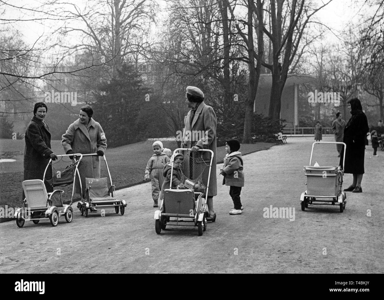 Frauen gehen am 07.03.1958, einem milden Frühlingstag, mit ihren Kindern und Kinderwagen im Park in Frankfurt spazieren. | usage worldwide Stock Photo