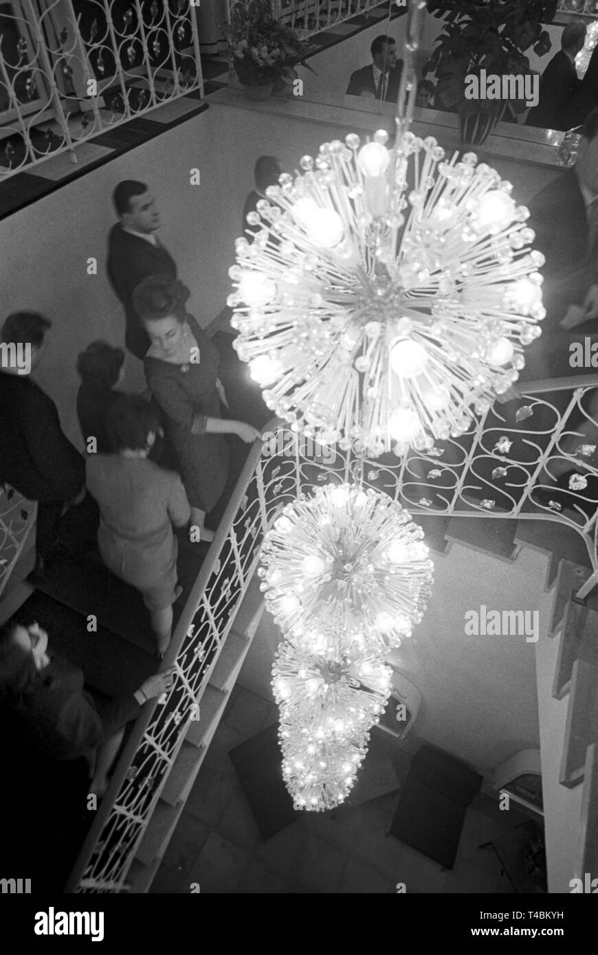 Theatregoers of the 'Frankfurter Komödie', a theatre, make their way to their seats for the play 'Zauber der Jugend' (translated as 'the magic of youth') on 20 Decemrber 1963. The picture shows a modern lamp, consisting of several spherical luminous elements. | usage worldwide Stock Photo
