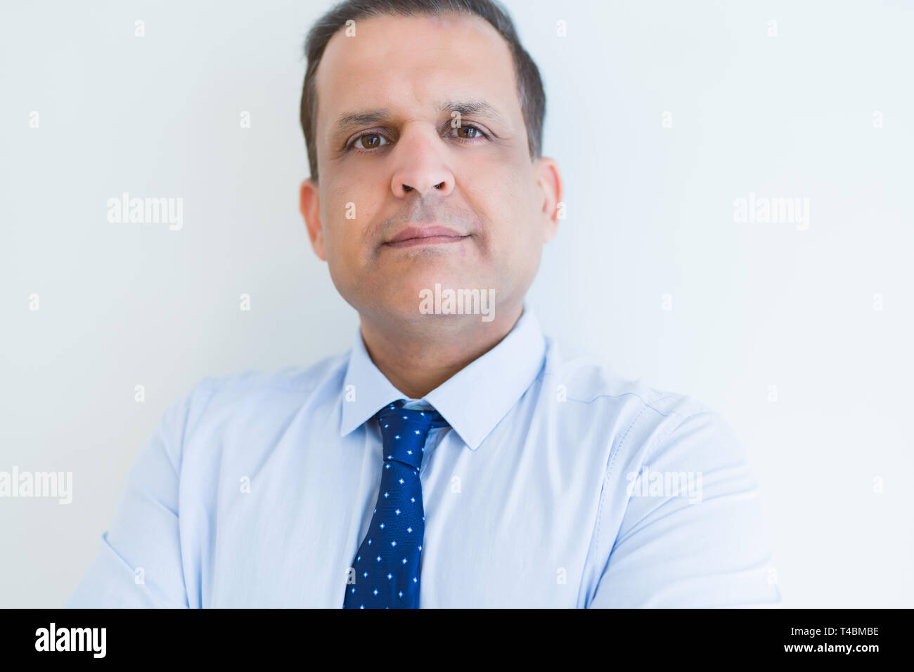 Middle age business man looking natural and relaxed with crossed arms over white wall background Stock Photo