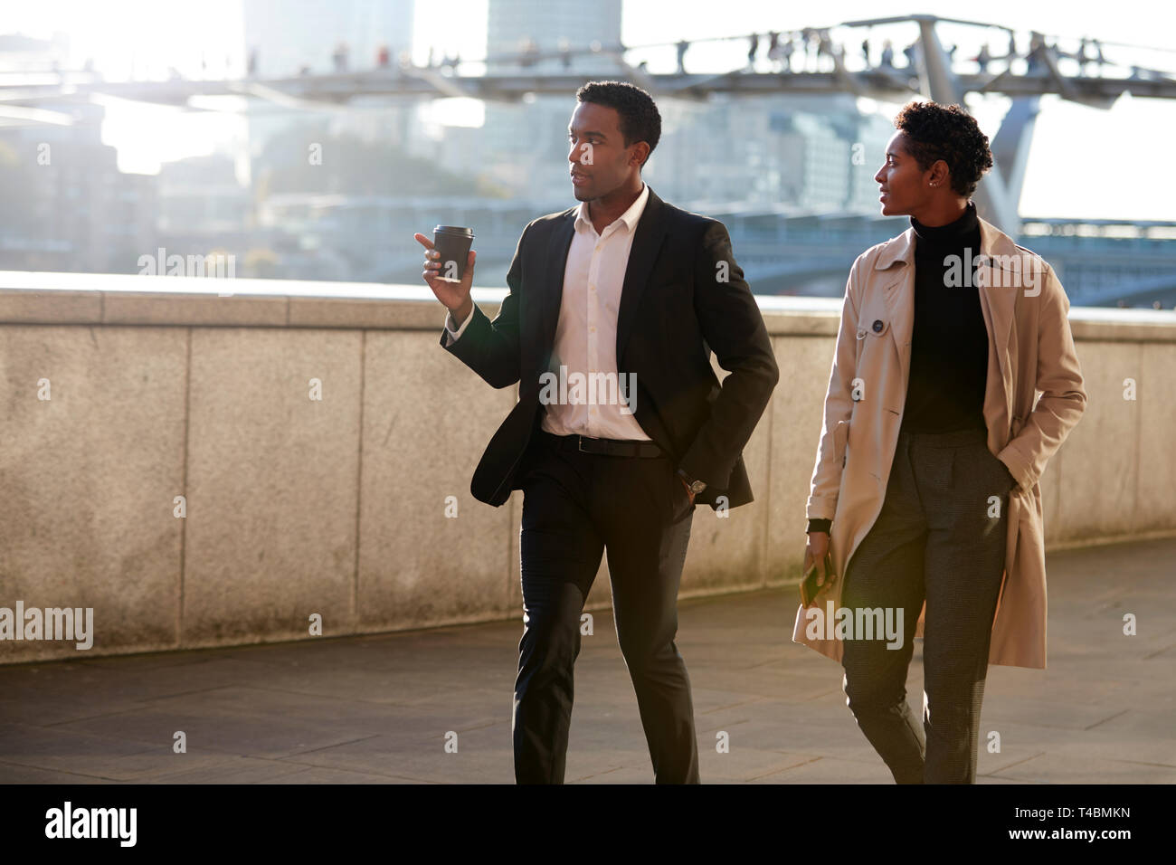 Two business colleagues walking by the Thames riverside in the city of London talking, man gesturing Stock Photo