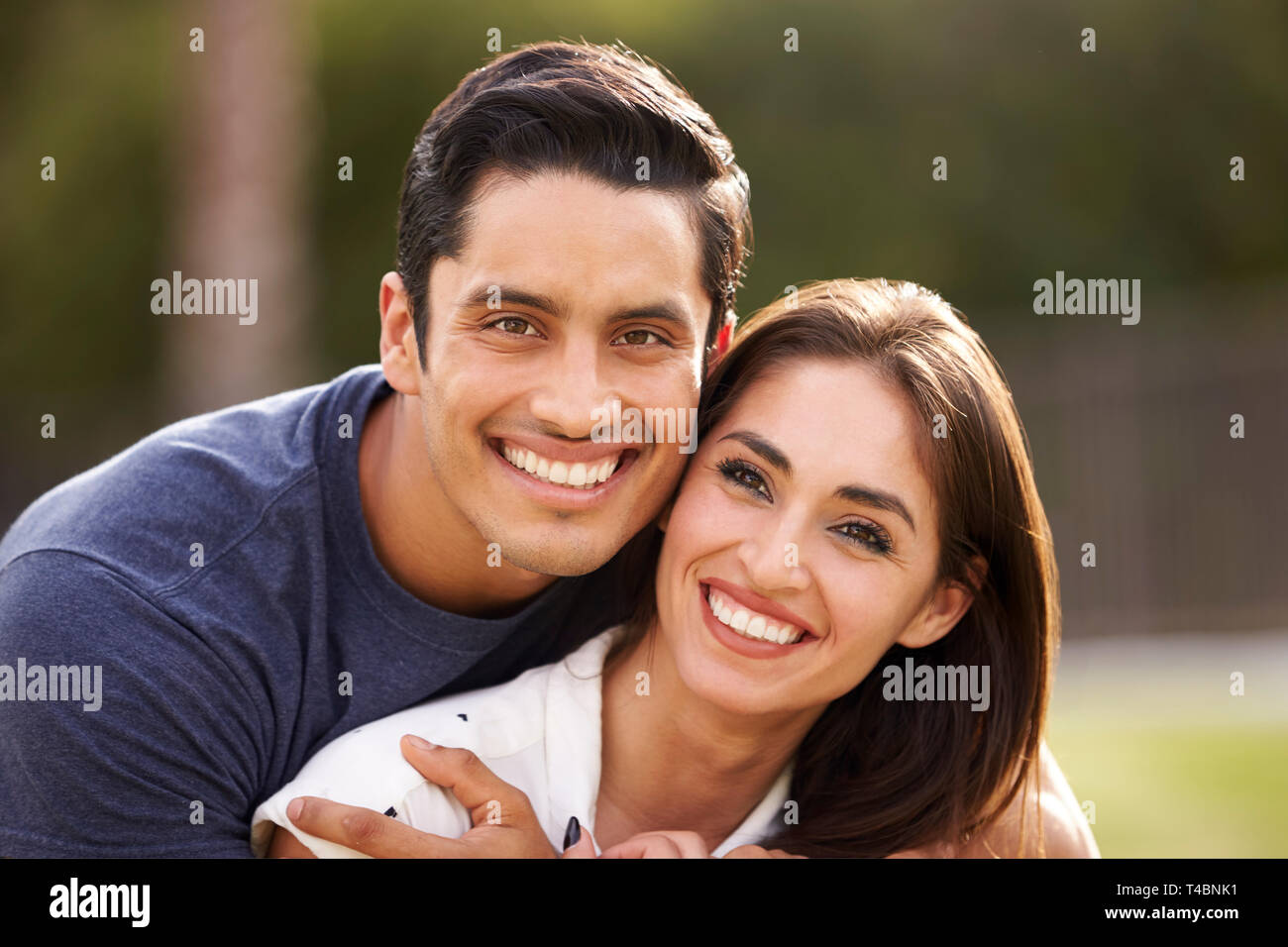 Young Hispanic couple looking to camera smiling, close up Stock Photo