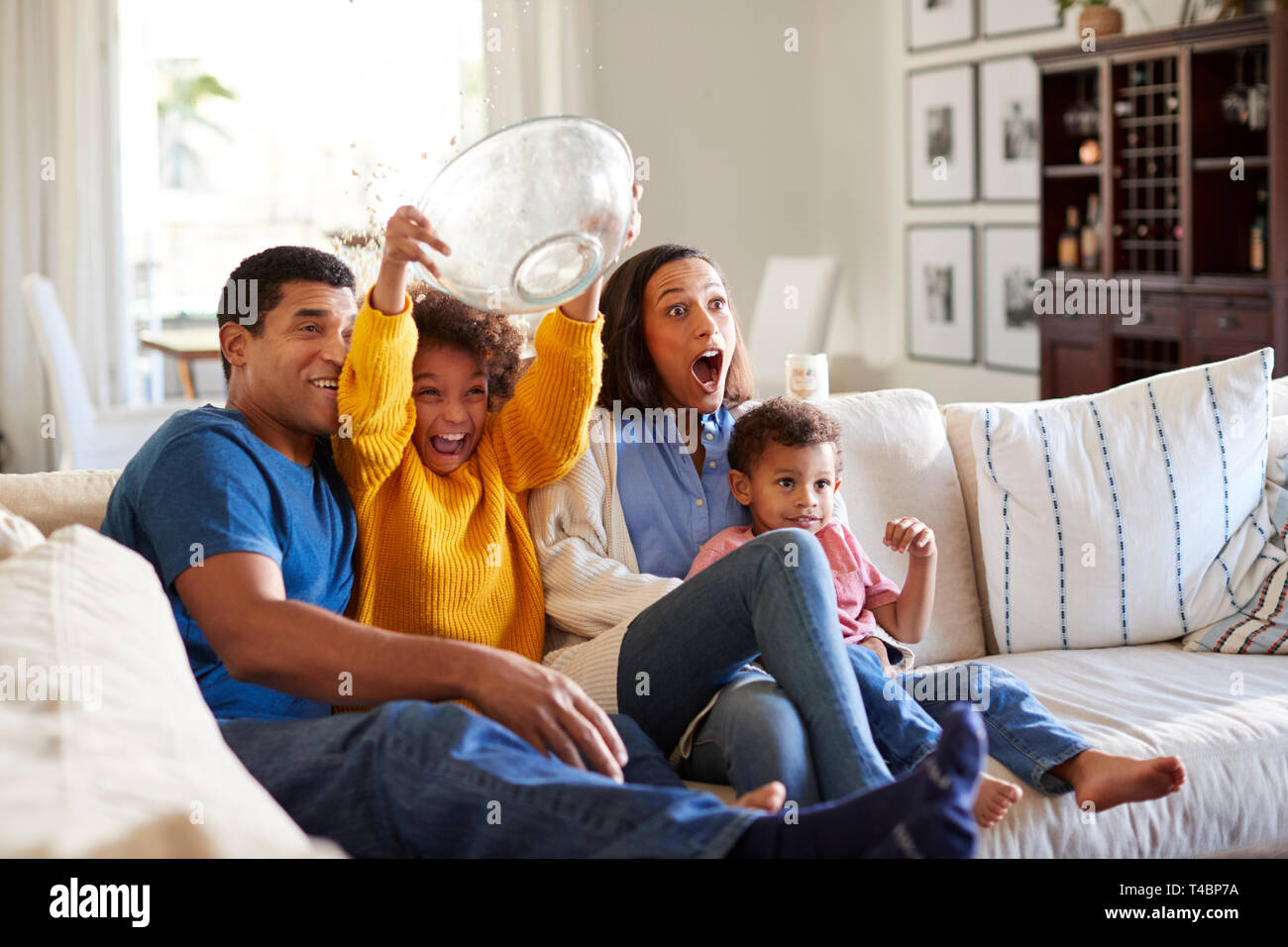 Happy Mixed Race Couple Relax On Couch In Living Room Watch Movie