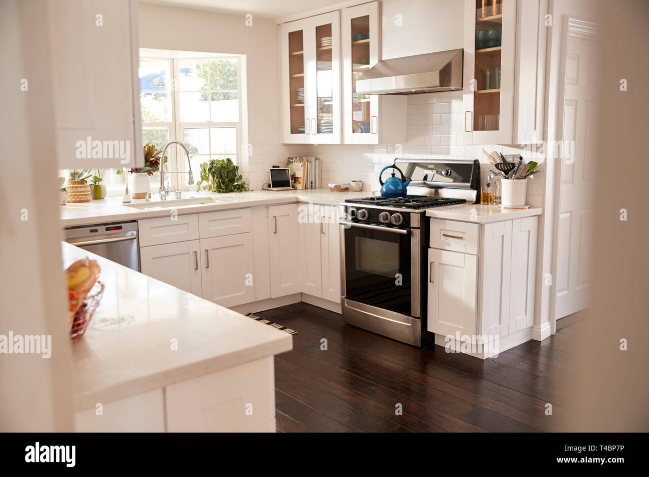 Domestic Family Kitchen With White Furniture And Dark Wooden